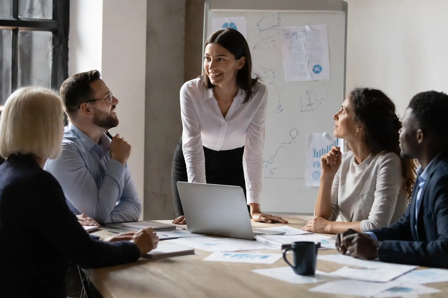 Una empresaria conversa con su equipo, mostrando firmeza y cercanía
